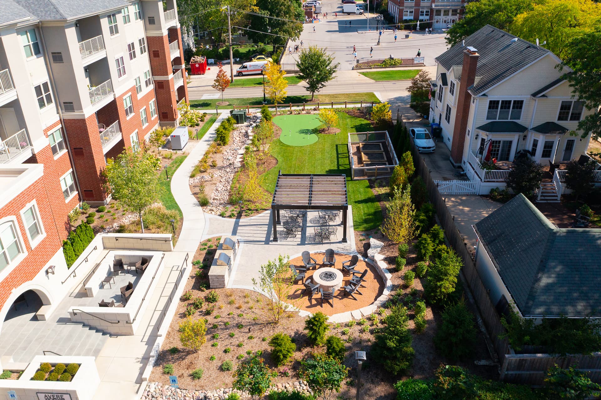 Aerial view of exterior amenities, fire pit, putting green, and landscape